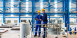 Two men looking at a tablet device in a manufacturing plant