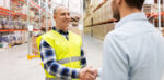 Two men shaking hands in a warehouse