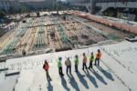 Seven construction workers looking over construction site on a sunny day